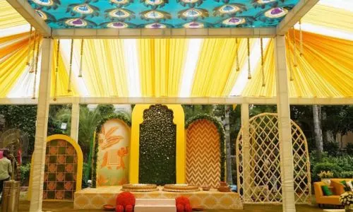 Grand Haldi lounge with stage backdrop at Grand Mantram Resort in Gurgaon featuring luxurious décor and vibrant pre-wedding setup
